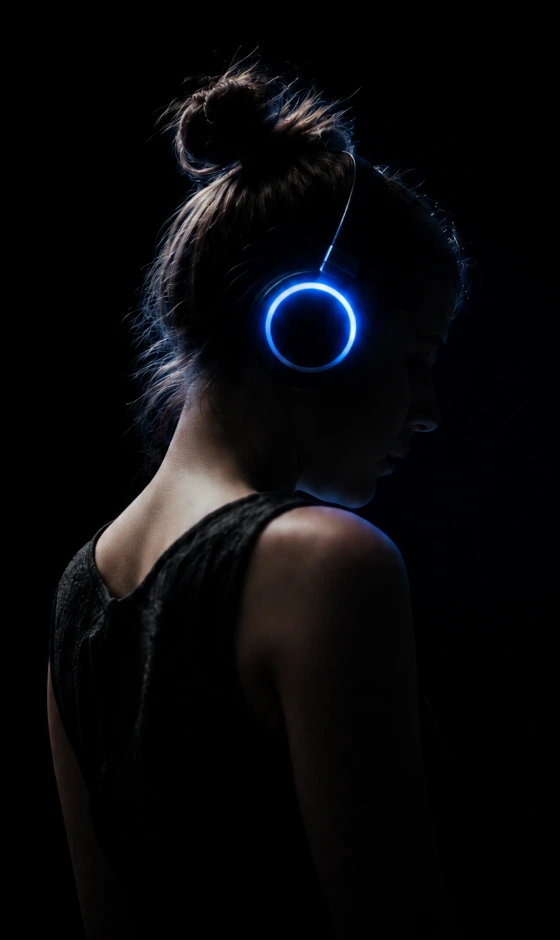 Experience Una figura emerge dall’oscurità indossando cuffie illuminate di blu